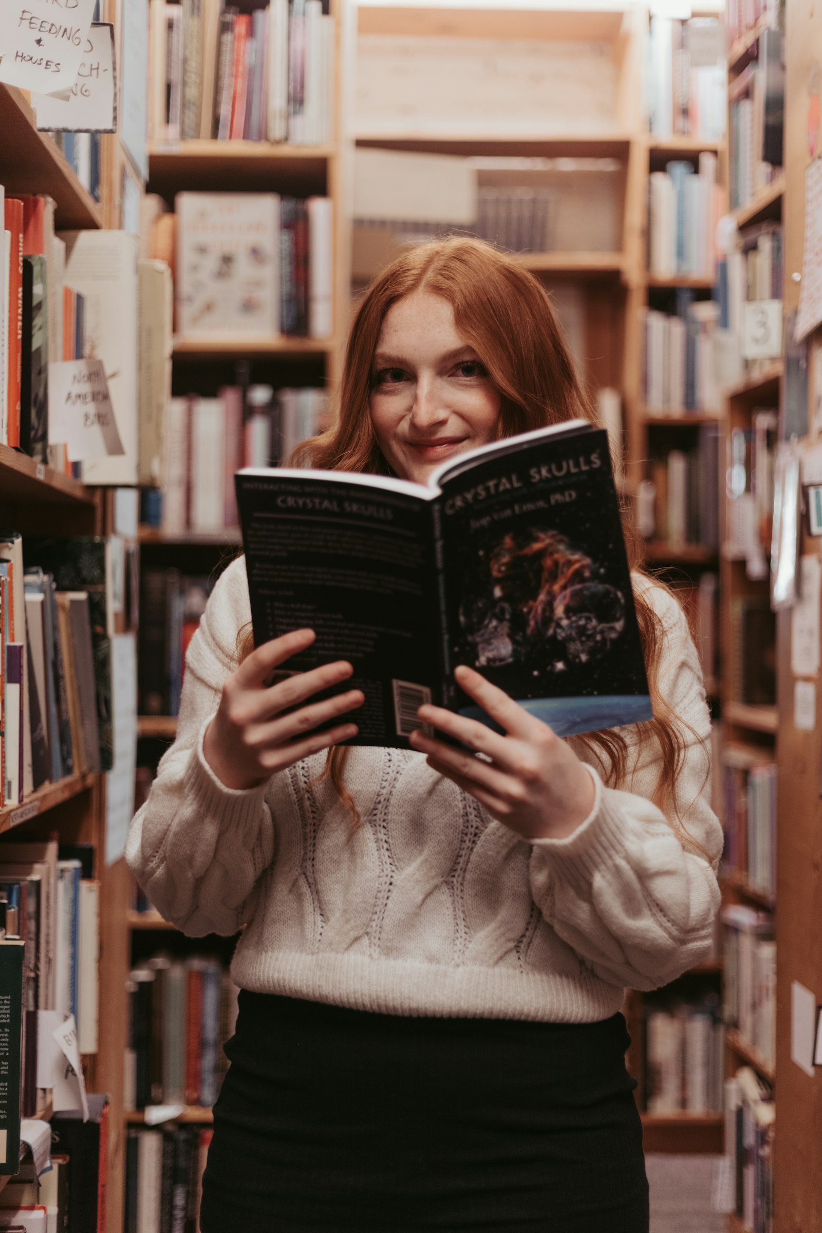 A reader enjoying a book among library shelves