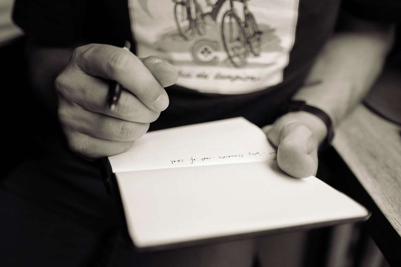 A writer making notes in an open book